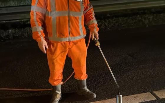 Wegdekreparatie bij nacht met gasbrander