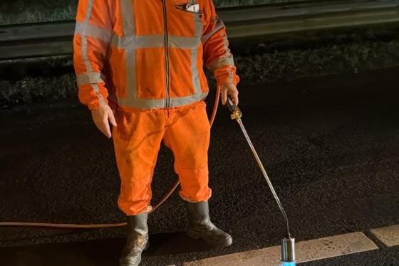 Wegdekreparatie bij nacht met gasbrander